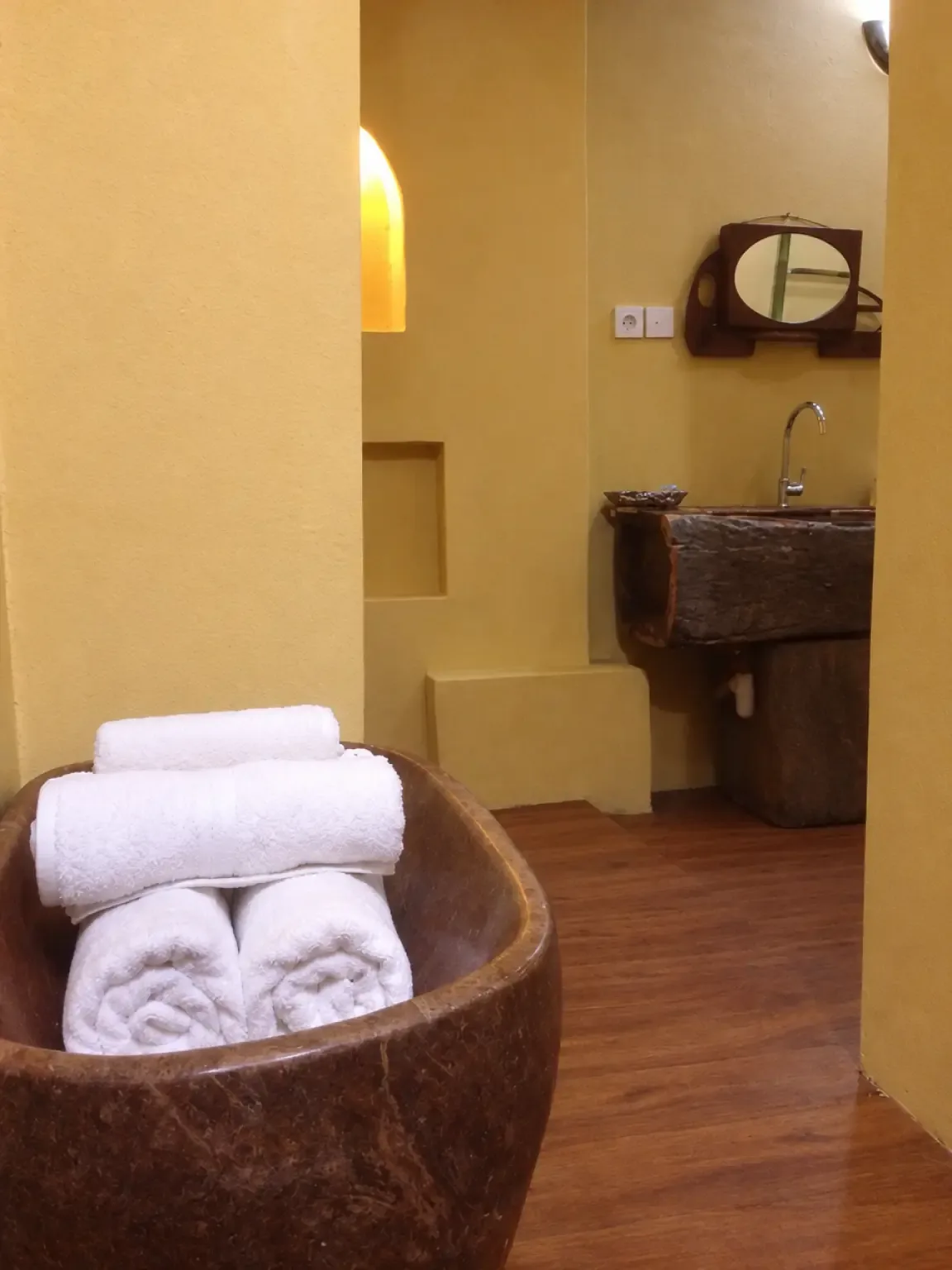 Detail kamar mandi pribadi dengan sentuhan batu dan kayu